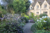 A gravel path winds through borders planted with perennials at The Manor, Little Compton.