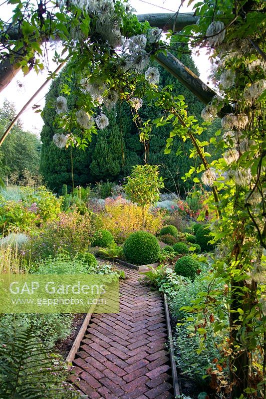 Wooden archway into formal vegetable garden in late summer at Lower House, Powys in Wales