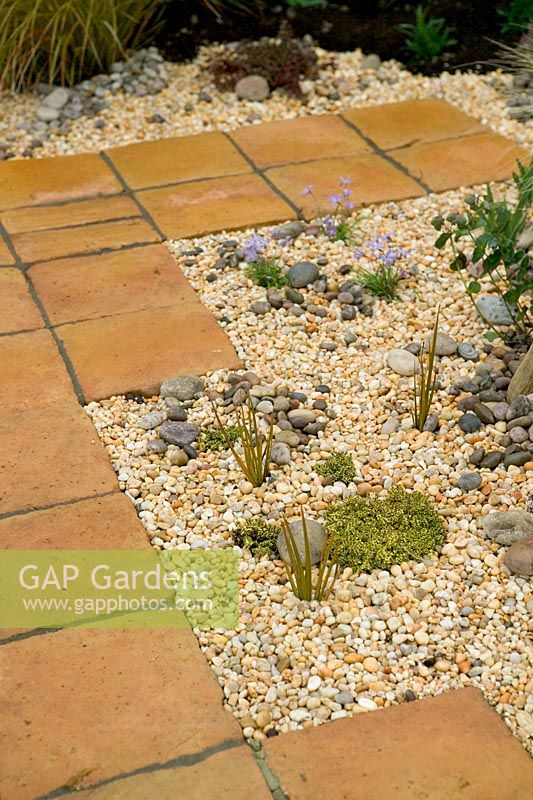 Dry garden with terracotta paving and gracel mulch at Capel Manor Show Gardens
