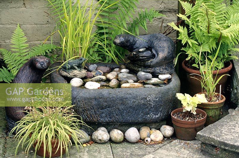 Stone sink used as a water feature with otter statues