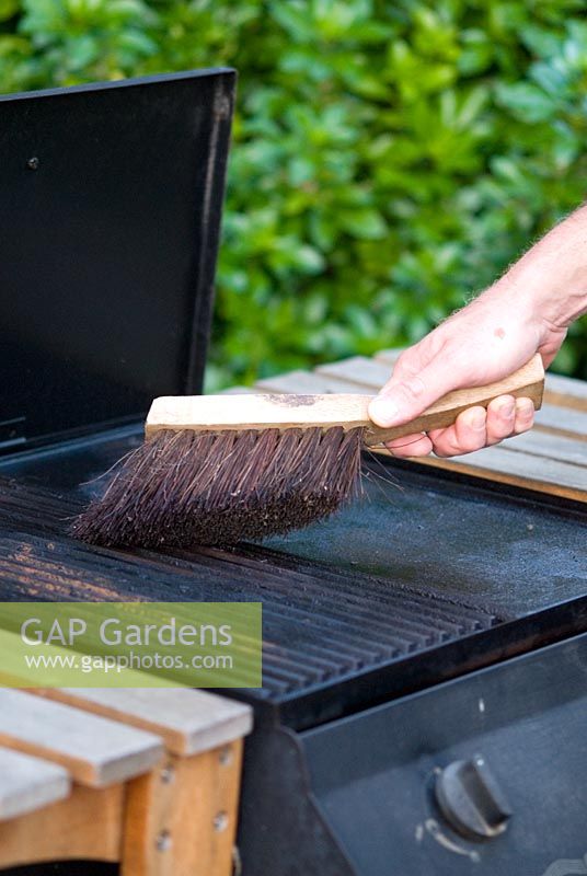 Man cleaning a Barbecue with a wire brush