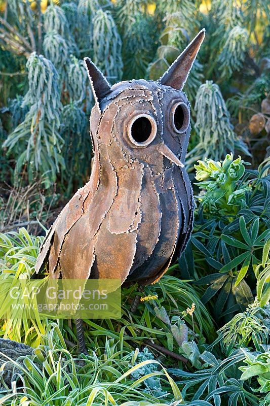 Rusty metal owl statue in frost