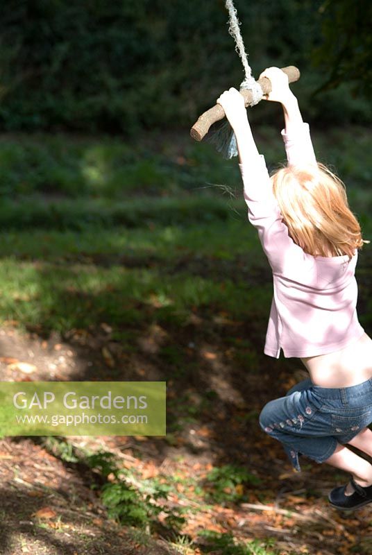 Girl on swing under a Aesculus hippocastanum - Common Horse Chestnut tree in autumn