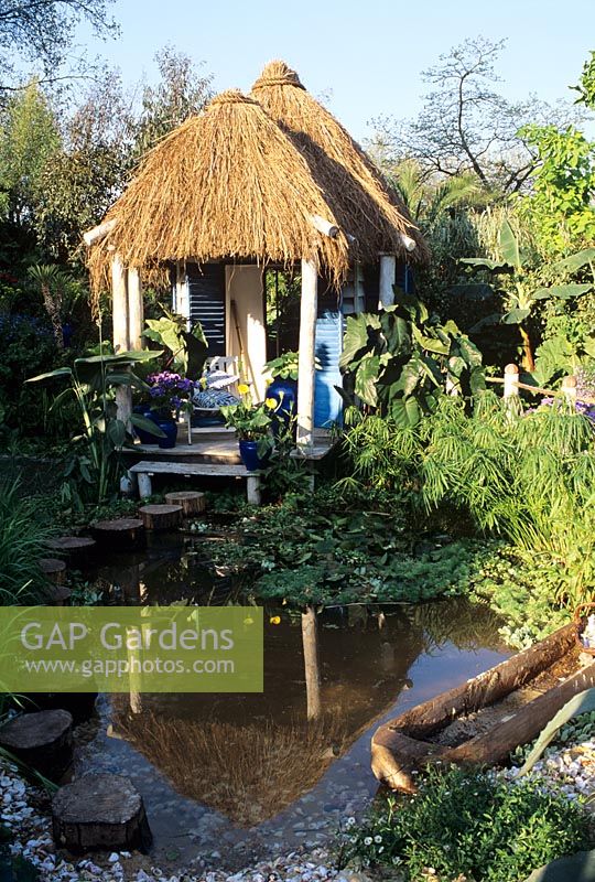 Thatched summerhouse on stilts in a large pool - Weyvale garden centre Chelsea 1996 