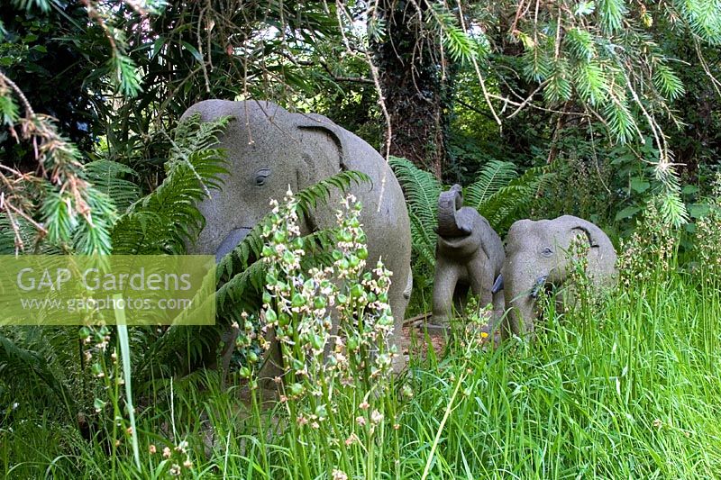 Stone Elephants as garden ornaments in a woodland setting