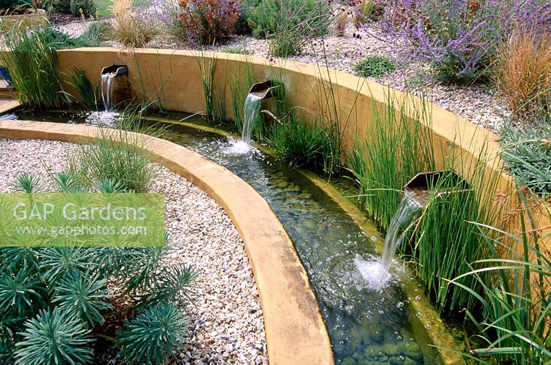 Gravel garden with water rill, rendered concrete walls and three spouts