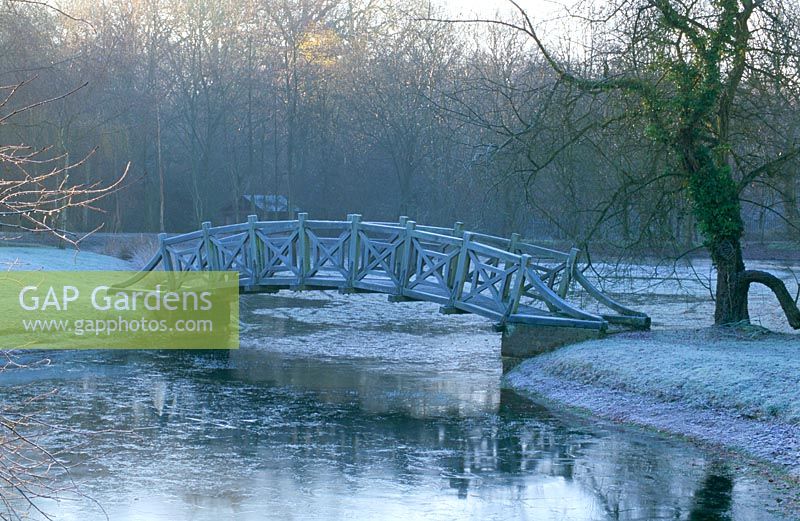 Ornamental bridge across a lake in the neo-classical park garden designed by Quinlan Terry - West Green House Garden, Hampshire 