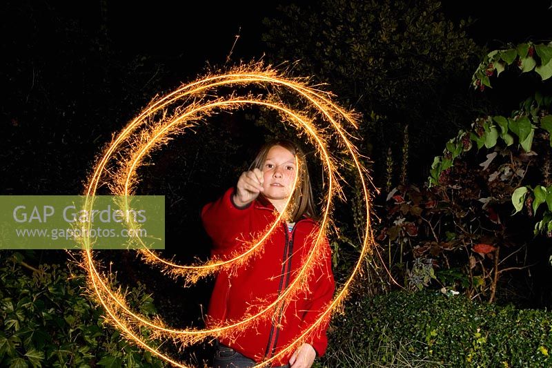 Girl playing with sparklers in the dark