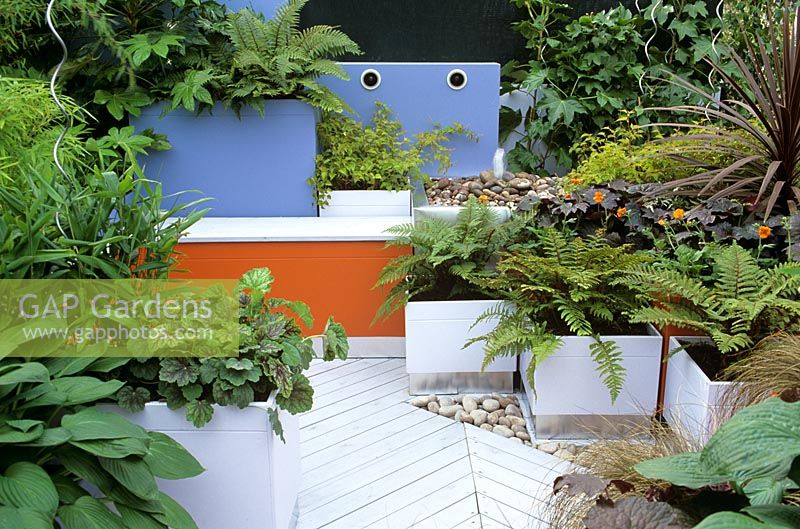 Foliage planting in painted MDF planters on timber decking in chic garden 