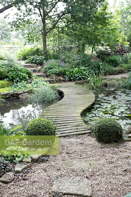 Wooden walkway over landscaped pond