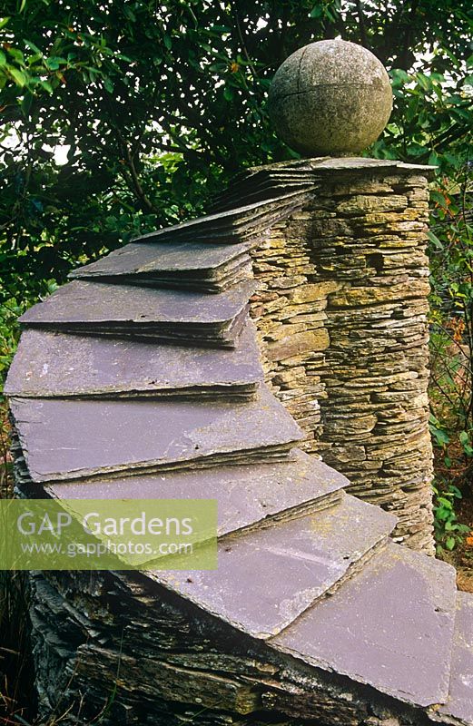 Curved stone wall with slate top and sphere