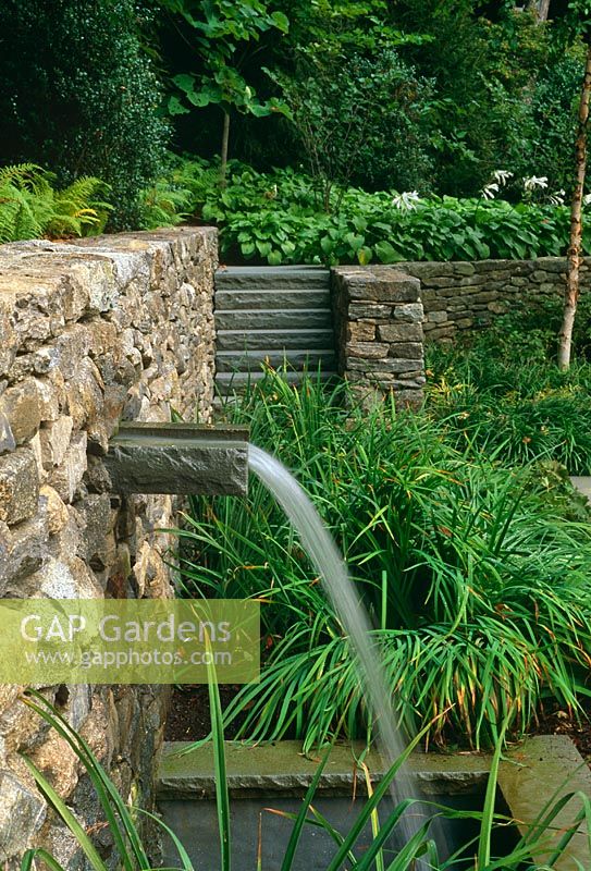 Lip waterfall in retaining wall with steps and Hostas in background - The Odrich Garden, Greenwich, Connecticut, USA