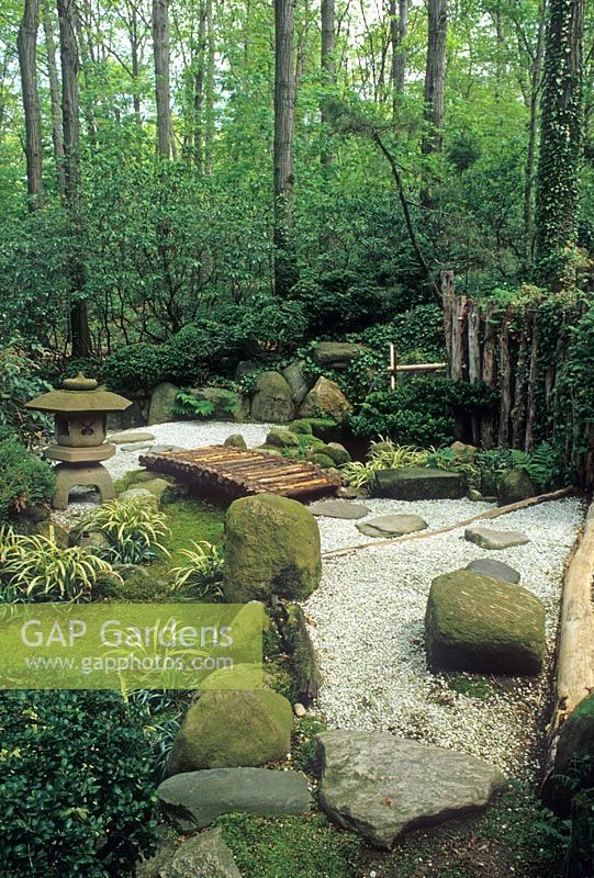Japanese style garden with gravel path leading to wooden bridge - The John P Humes Japanese Stroll Garden NYC, USA
