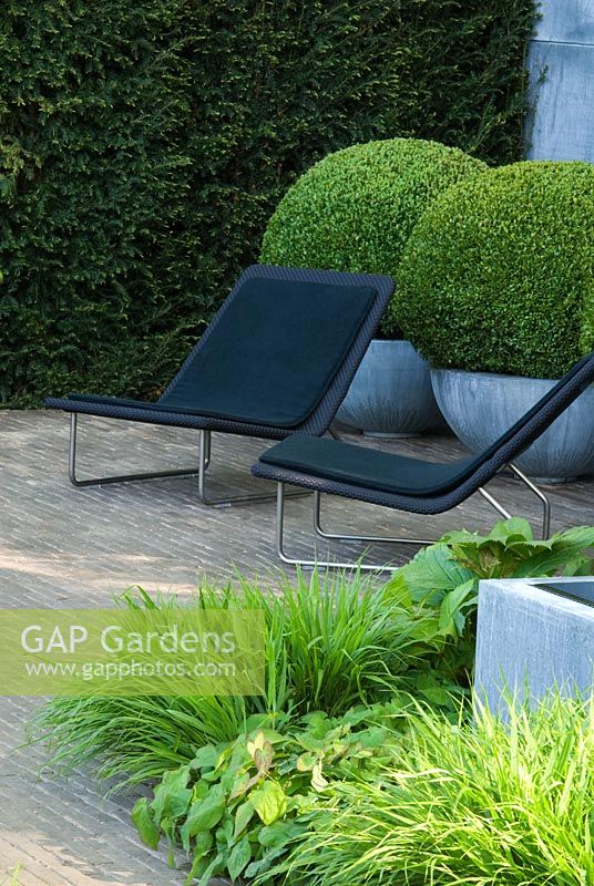 Garden chairs, topiary Buxus balls in zinc containers and green planting - The Laurent Perrier Garden - Winner of Gold Medal and Best Show Garden RHS Chelsea 2008
