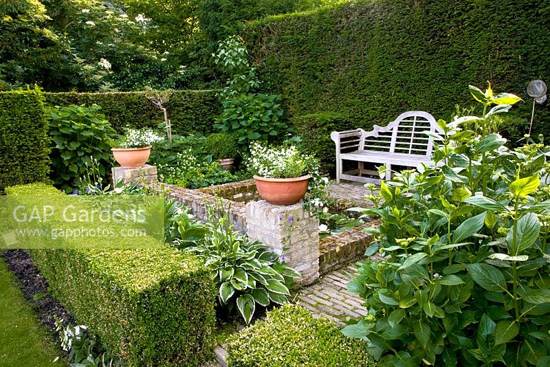 Garden room in formal garden with wooden bench