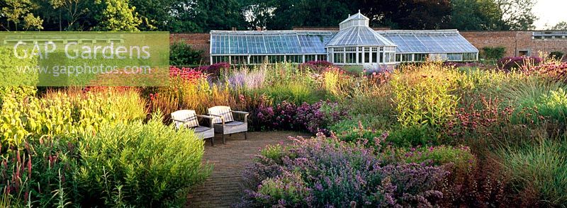 Seating area and Glasshouse inThe Perennial Meadow at Scampston Hall designed by Piet Oudolf