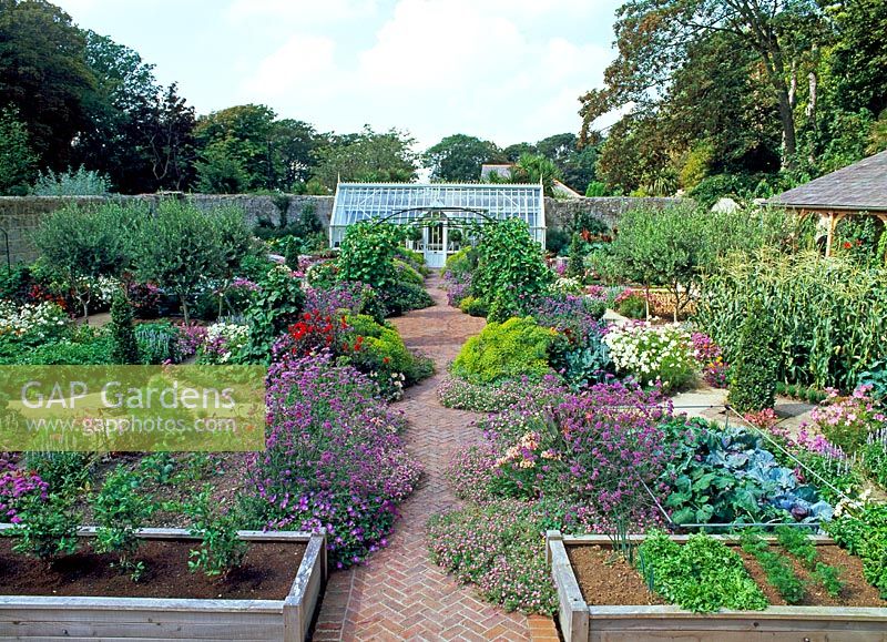 Overview of walled garden, with greenhouse, raised oak beds, planted with vegetables and flowers - The walled garden at Haddon Lake House