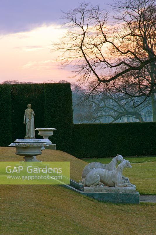 Urns, greyhound statues and yew hedging at dawn in winter - Brodsworth Hall, Yorkshire