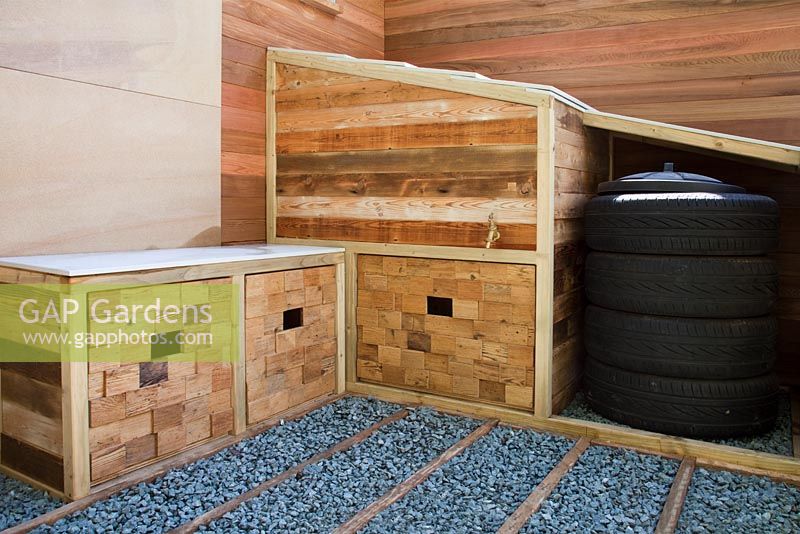 A seat with storage areas and a compost bin created from car tyres with gravel and timber path in the Marshalls Living Street Garden, sponsored by Marshalls plc - Silver-Gilt Flora medal winner at RHS Chelsea Flower Show 2009
