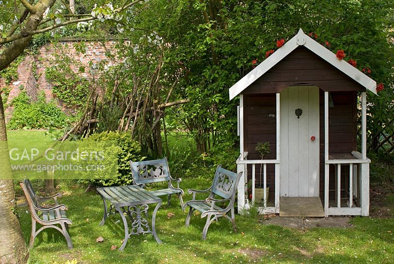 Wooden wendyhouse with childrens table and chairs - Poulton Hall, NGS garden, Cheshire