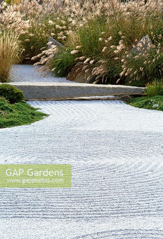 Japanese inspired garden for the offices of a Pharmaceutical company, Boston. Gravel and grasses with stone bridge.