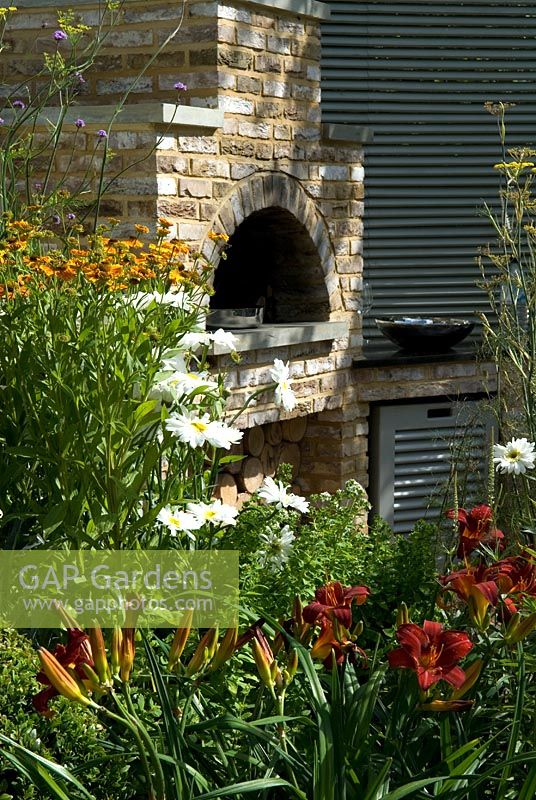 Wood-burning oven in garden setting for al fresco cooking and dining. 'A Chef's Garden'. Sponsors - Jacksons Fencing, Seccombe Building Materials. Edible gardens. Outdoor living. Silver Award Winner - RHS Hampton Court Flower Show 2009