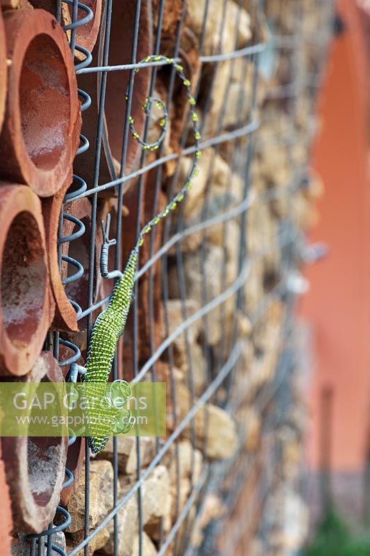 Insect garden wall with wire lizard sculpture