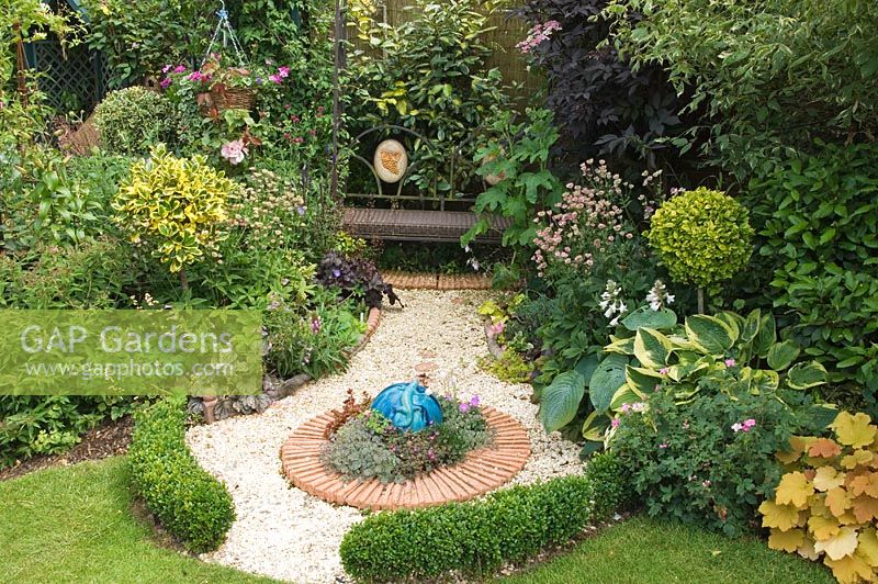 Garden bench and gravel path, with clipped box hedging