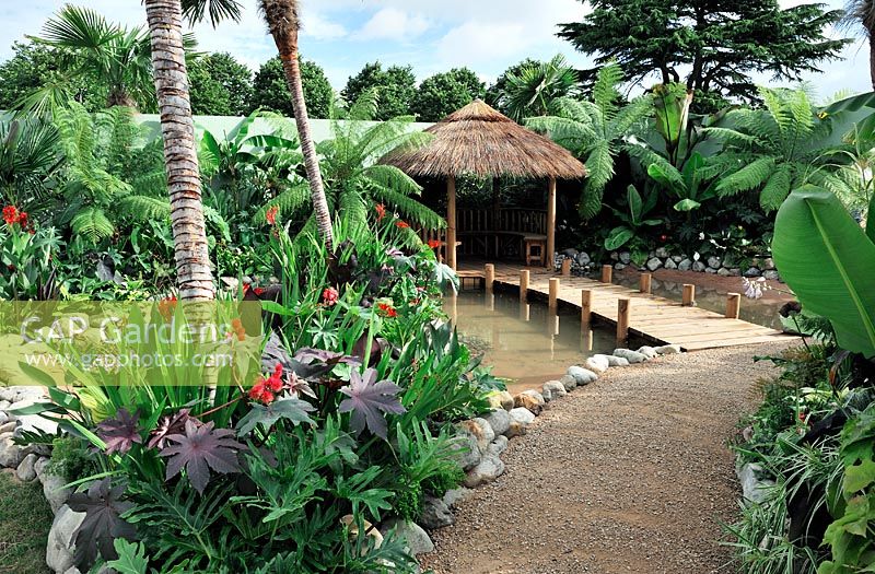 Lush Exotic planting with stilted breeze house,Hampton Court Flower Show