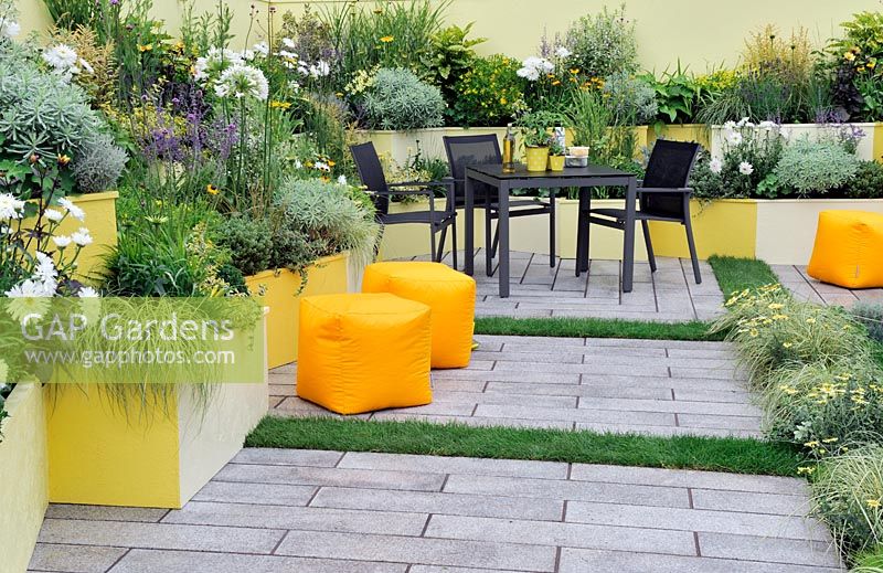 Patio garden with extensive planting in brightly painted raised beds - RHS Tatton Park Flower show