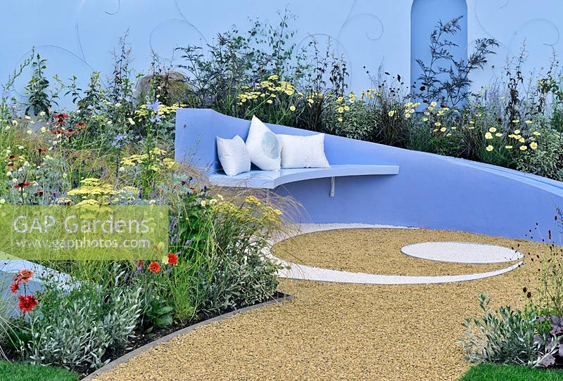 Stone seat on a curving and sloping retaining wall. RHS Tatton Park Flower show