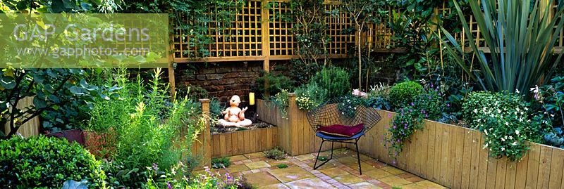 Raised beds, pot plants, paved patio and trellis in rear garden - After makeover of a Brixton garden for Channel 4 Garden Doctors 