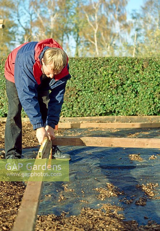 Making a pergola - Level the ground using planks before starting the uprights, it's a lot easier to manipulate this at ground level than it is in the air