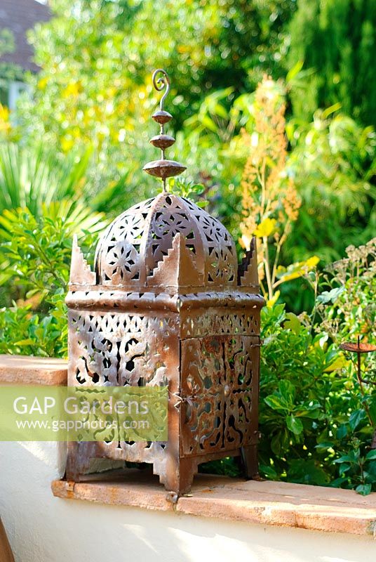 Moroccan pierced ironwork candle lantern on wall