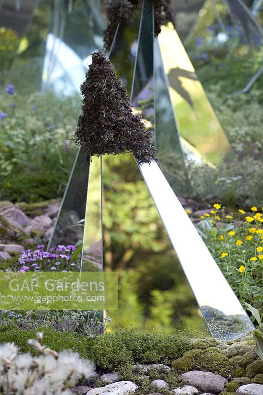 Glass mirrors on diamond shaped structures amongst moss covered rocks. Alpine flowers. Lights and Colours of the Alps garden, Bronze medal winner, RHS Chelsea Flower Show 2010
 