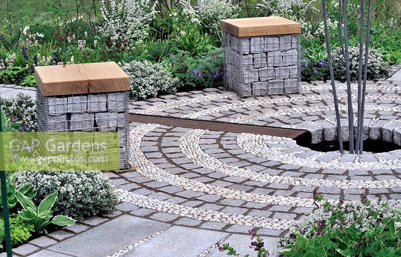 Gabion seats in circular garden with cobble stone and pebble circles - RHS Malvern Spring Gardeneing Show