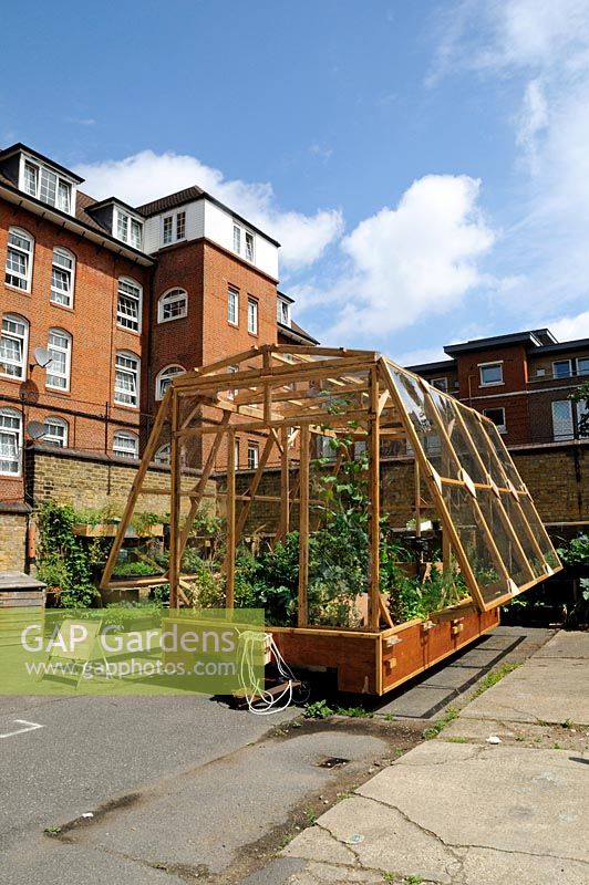 Travelling greenhouse, pulled by people, parked in St Lukes Community Allotments, Clerkenwell, London Borough of Islington UK