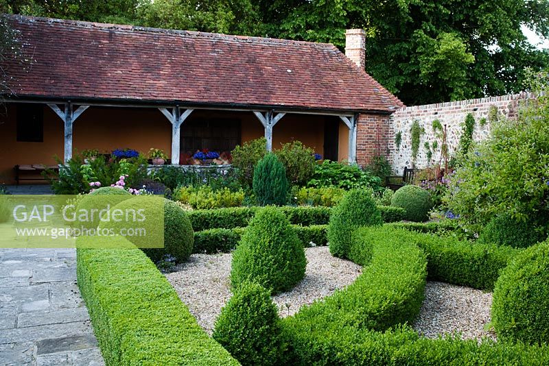 Stone pathway through formal topiary garden to verandah - Rymans, Sussex
