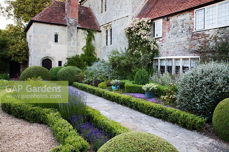 Stone pathway through formal parterre and Lavandula alongside mixed summer border - Rymans, Sussex