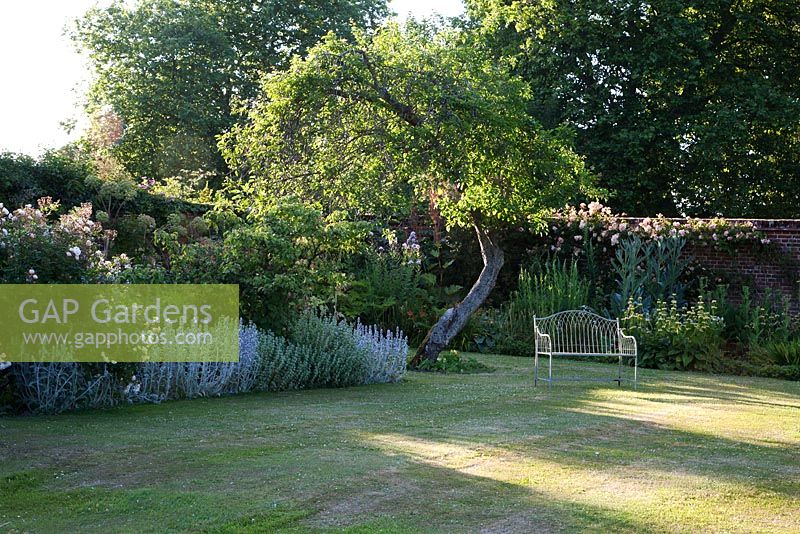 Decorative metal seat in formal walled garden - Rymans, Sussex