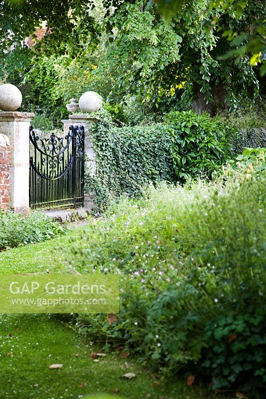 Decorative wrought iron gate in 'wild' garden - Rymans, Sussex 