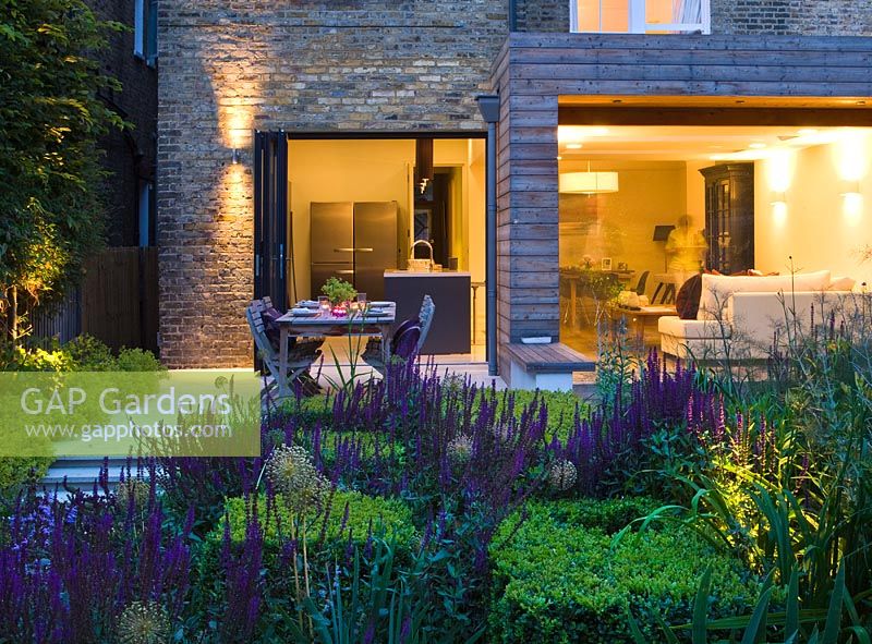 Urban house and garden lit up at night. London 
 