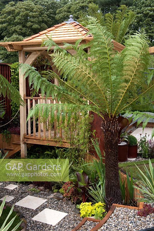 Wooden summerhouse and tropical planting. Colonial Chic and Bajan Roots - RHS Tatton Park 2010