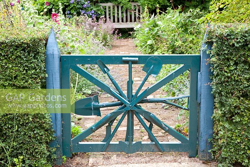 Painted blue garden gate made from old gardening tools