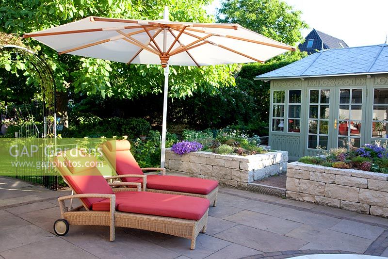 Paved terrace with loungers and parasol