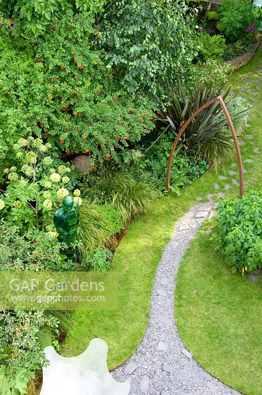 Urban garden viewed from above, showing resin water feature and curved slate path under metal arch. Yulia Badian garden, London, UK