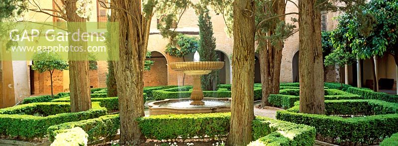 Fountain and topiary hedges in a courtyard - Gardens of the Alhambra, Granada, Spain