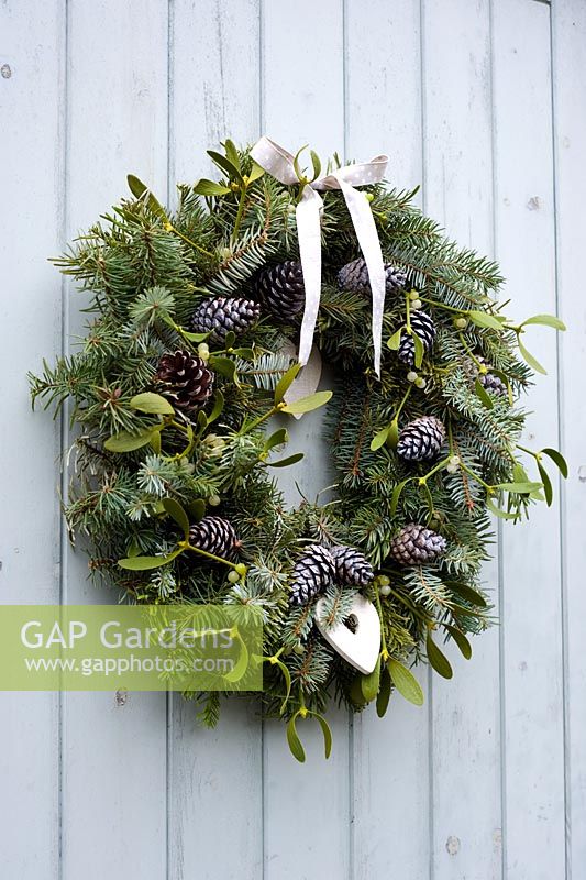Pine wreath with fir cones, mistletoe, ribbon and hearts