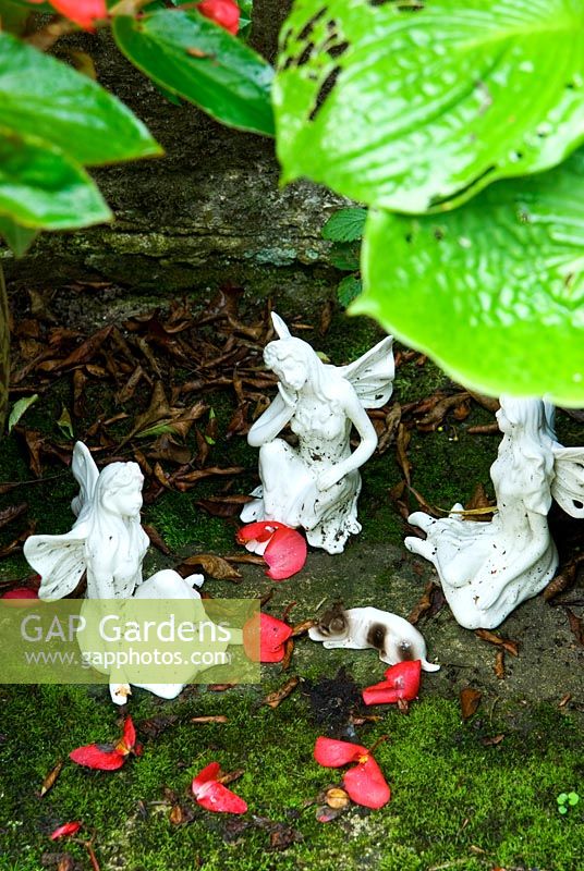 Fairy figurines beneath hosta leaves. Pinsla Garden, Cardinham, Cornwall, UK