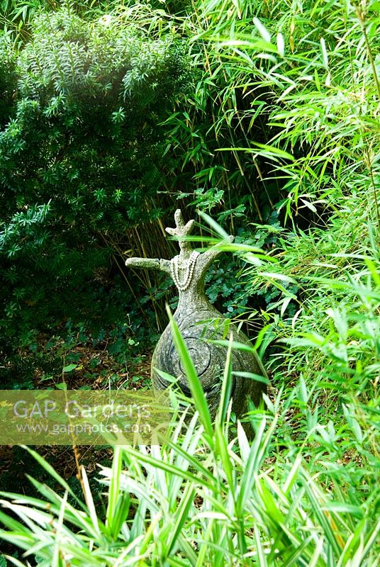 Concrete figure with pearl necklace inside bamboo grove - Pinsla Garden, Cardinham, Cornwall